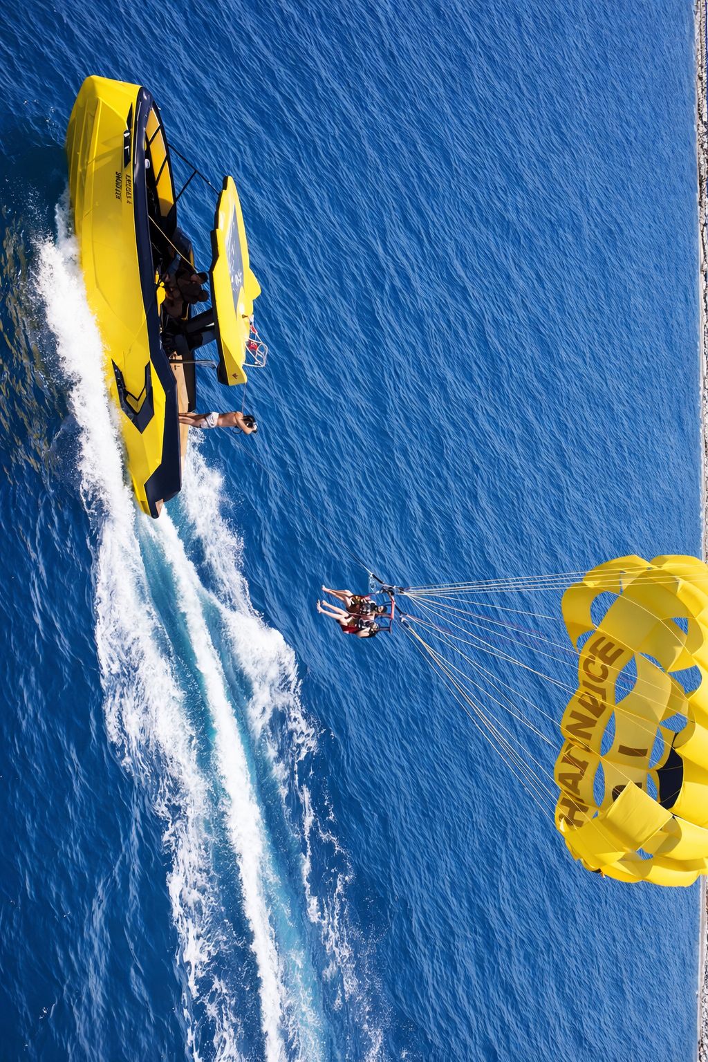 Aerial parasailing scene with boat and parachute