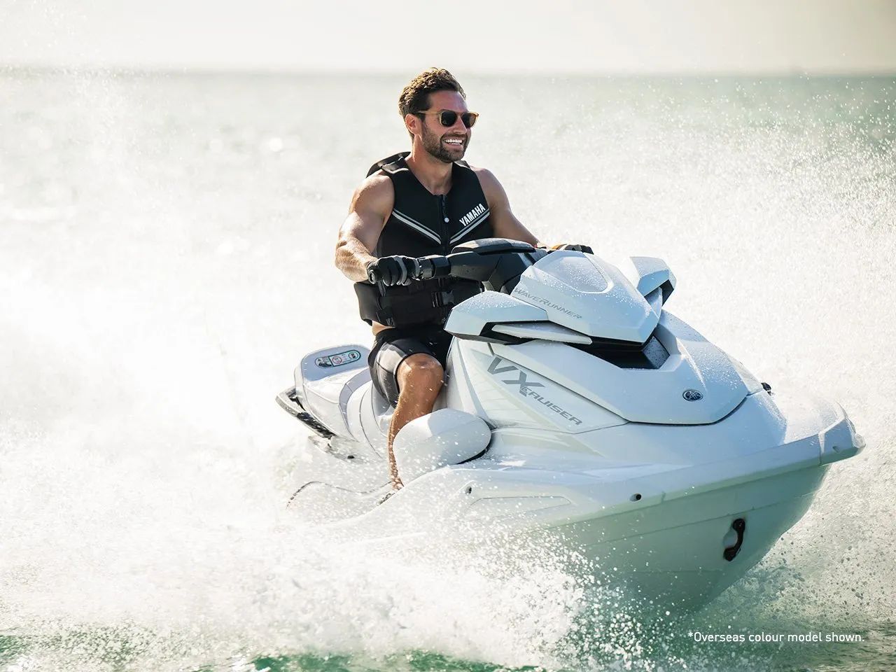 Jet-ski rider moving through sea spray